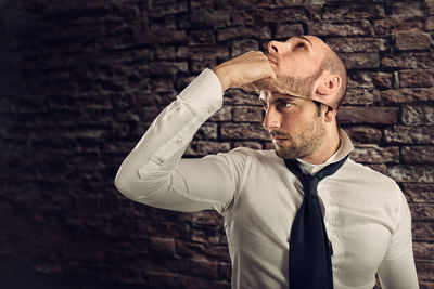 Portrait of man standing against wall