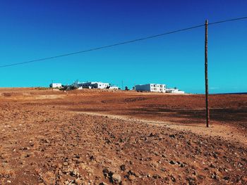 Dirt road against clear blue sky