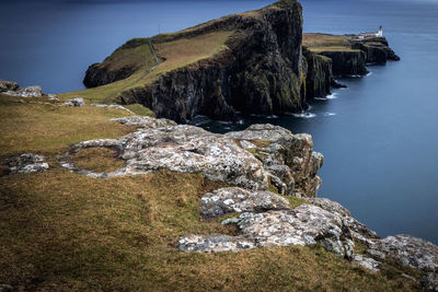 Rock formations by sea against sky