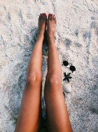 Low section of young woman legs on beach