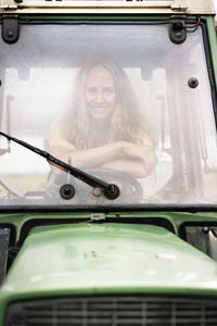 Portrait of smiling woman sitting in a tractor