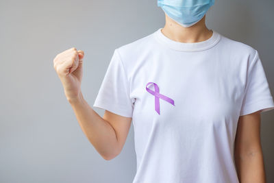 Midsection of woman standing against white background