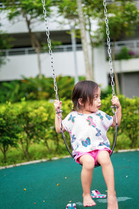 Rear view of girl on swing at playground