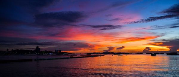 Scenic view of sea against dramatic sky during sunset