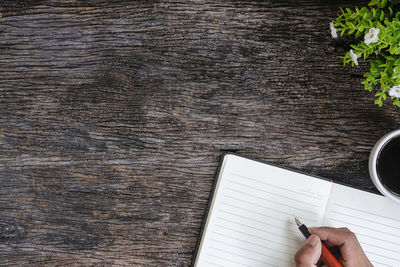 Directly above shot of person writing in book on table