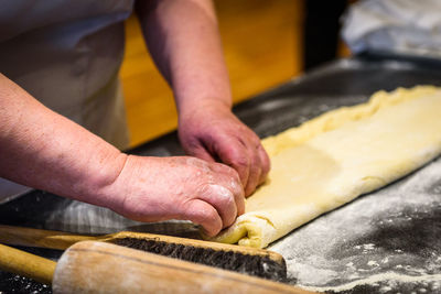 Midsection of man preparing cookies with dough at counter