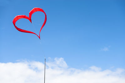 Low angle view of heart shape against blue sky