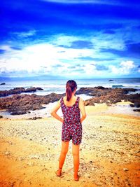 Full length of young woman standing on beach