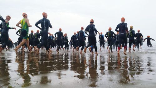 Panoramic view of people by sea against sky