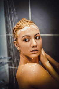 Close-up of woman taking shower in bathroom