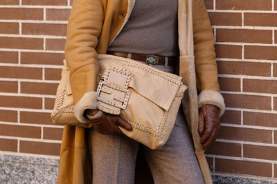 Midsection of woman standing against wall