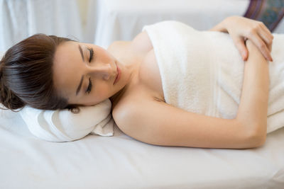 Young woman lying on massage table in spa