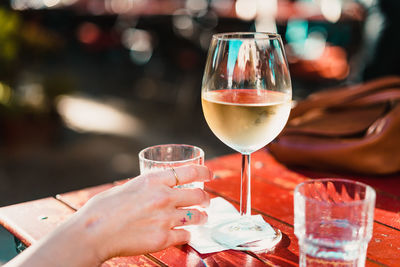 Cropped hand holding glass at table