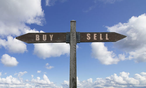 Low angle view of cross sign against blue sky