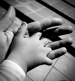 Cropped child holding father hand at outdoors