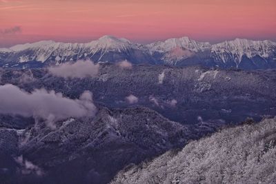 Scenic view of snowcapped mountains against sky during sunset