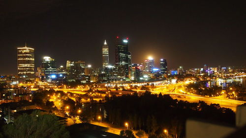 Illuminated buildings in city against sky at night