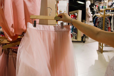 Cropped image of woman holding dress at store