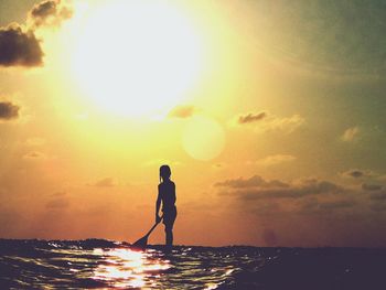Silhouette of people on beach at sunset