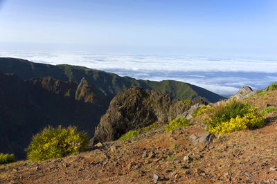 Scenic view of mountains by clouds against sky