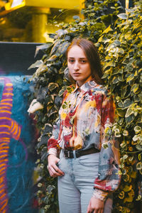 Portrait of smiling young woman standing against multi colored background