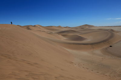 Scenic view of desert against blue sky