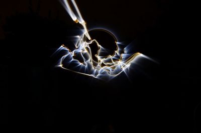 Close-up of illuminated lighting equipment against black background