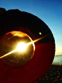 Close-up of illuminated light bulb against sky