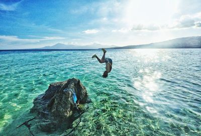 Man surfing in sea against sky