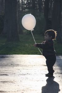Side view of toddler holding a balloon