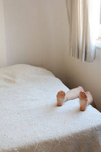 Woman lying on bed at home