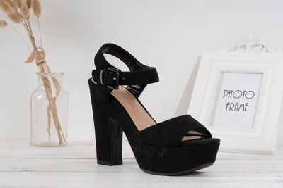 Close-up of shoes on table against wall