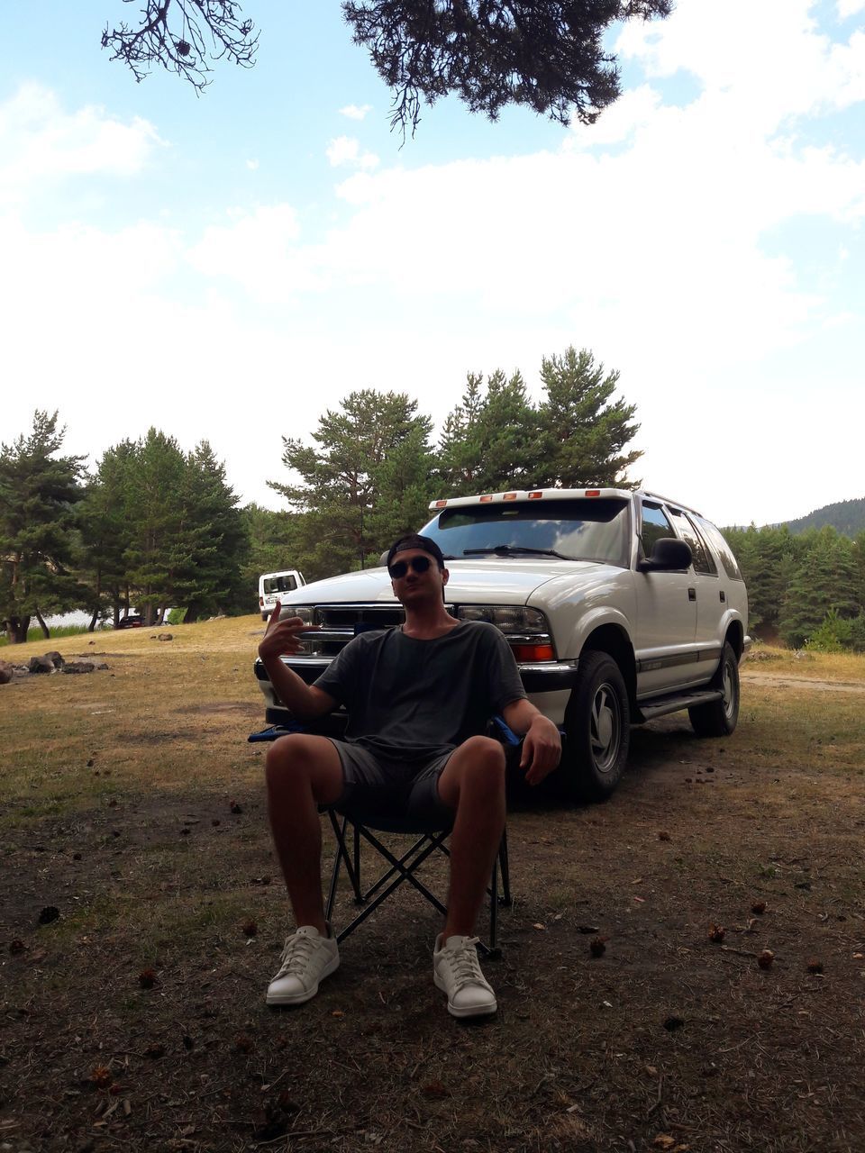 MAN SITTING IN CAR ON FIELD