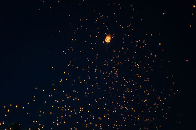 Low angle view of fireworks against sky at night