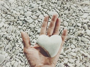 Cropped image of person hand on pebbles