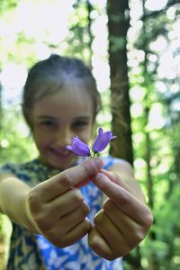 Portrait of girl holding purple flower