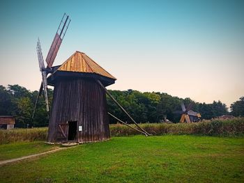 Traditional windmill on field against sky