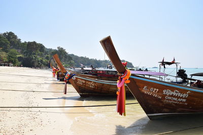 Boat moored on beach against clear sky