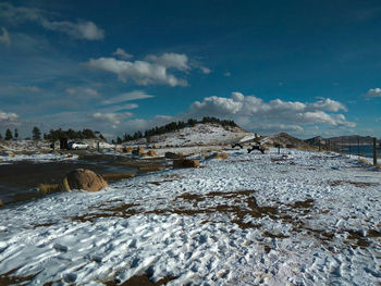 Surface level of water flowing through rocks against sky