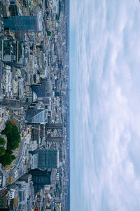 Aerial view of town by sea against sky