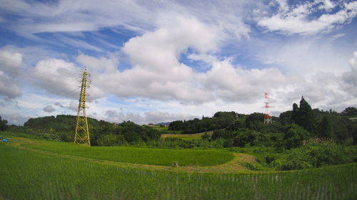 Rural landscape against cloudy sky