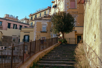 Low angle view of steps amidst buildings against sky