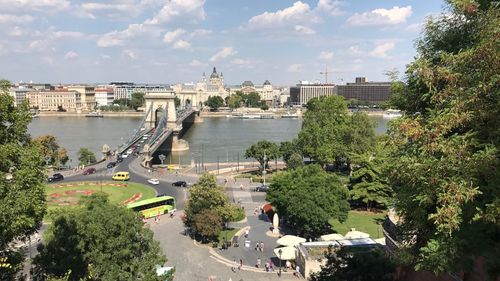 High angle view of city by river against sky