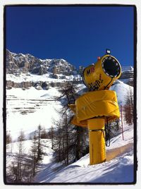 Scenic view of snow covered mountains against blue sky