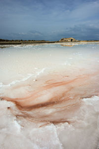 Salt flats against sky on sunny day