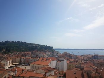 High angle view of townscape by sea against sky