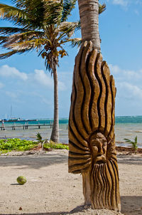 Palm tree by sea against sky