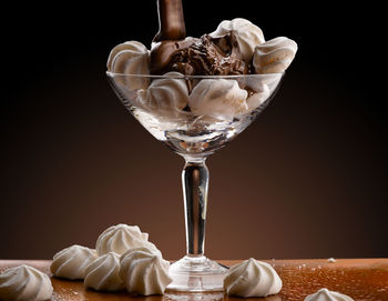 Close-up of wine glass on table against black background