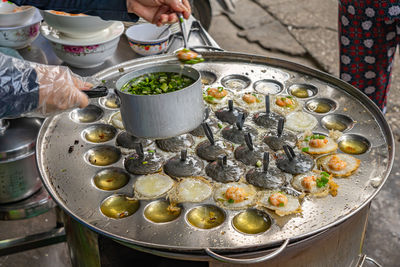 Woman making vietnamese tiny sizzled pancake- banh khot vung tau