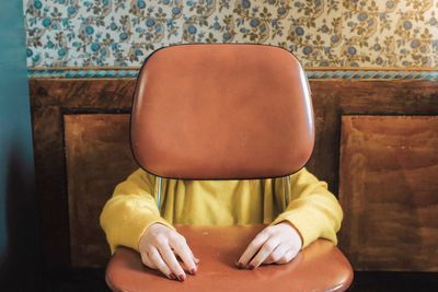 Midsection of woman sitting on sofa